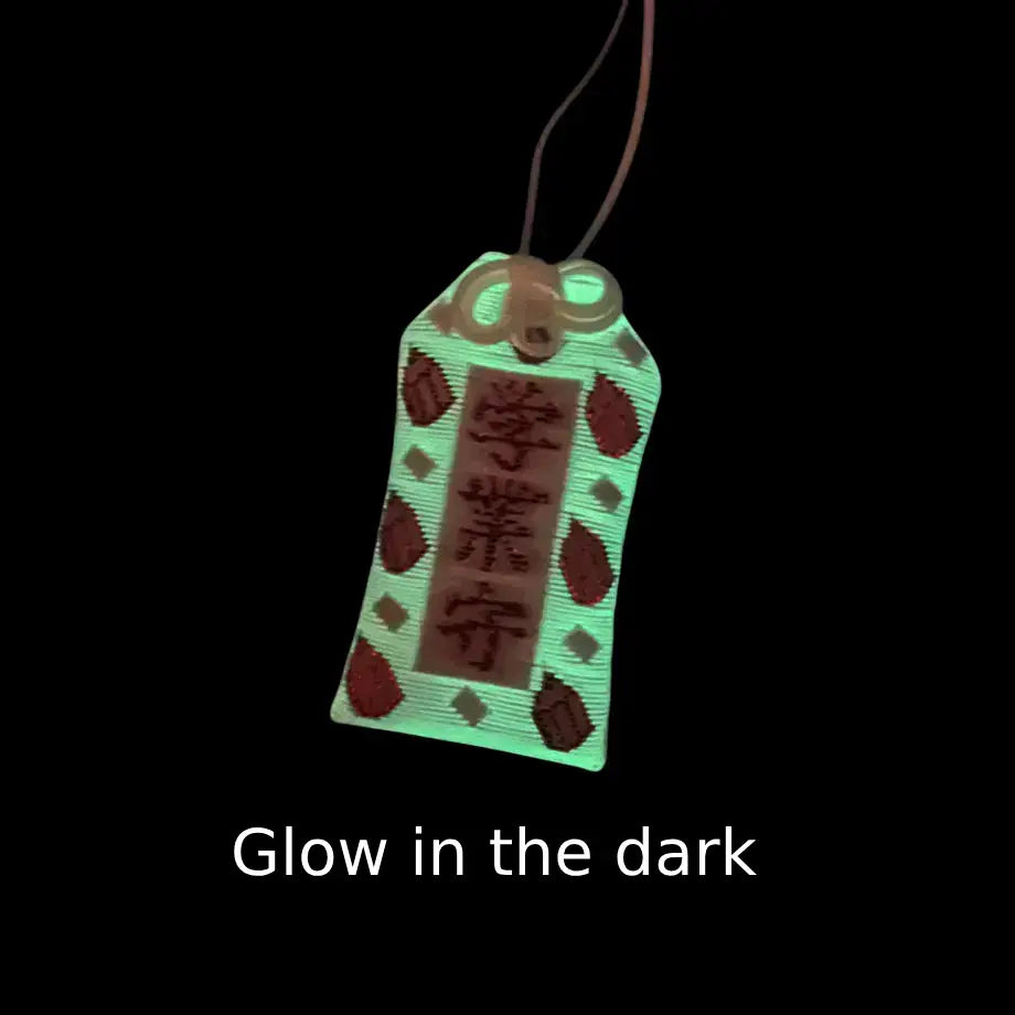 Glow-in-the-dark view of academic success omamori (学業守) from Izusan Shrine, Shizuoka – ivory variant shown glowing in darkness