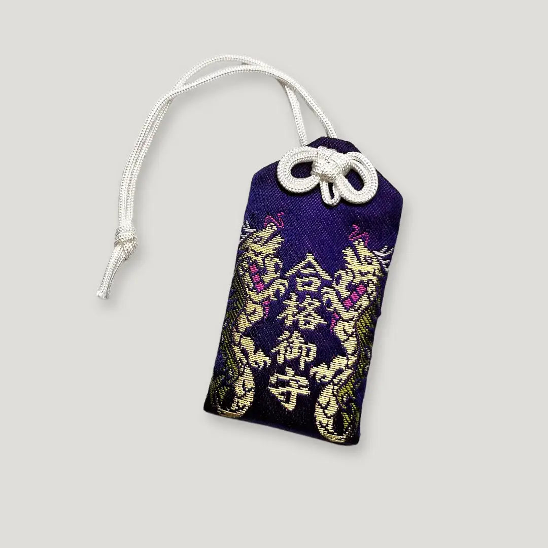 Exam success omamori (合格守) from Izusan Shrine – purple Japanese charm with twin golden dragons, symbolizing achievement and protection