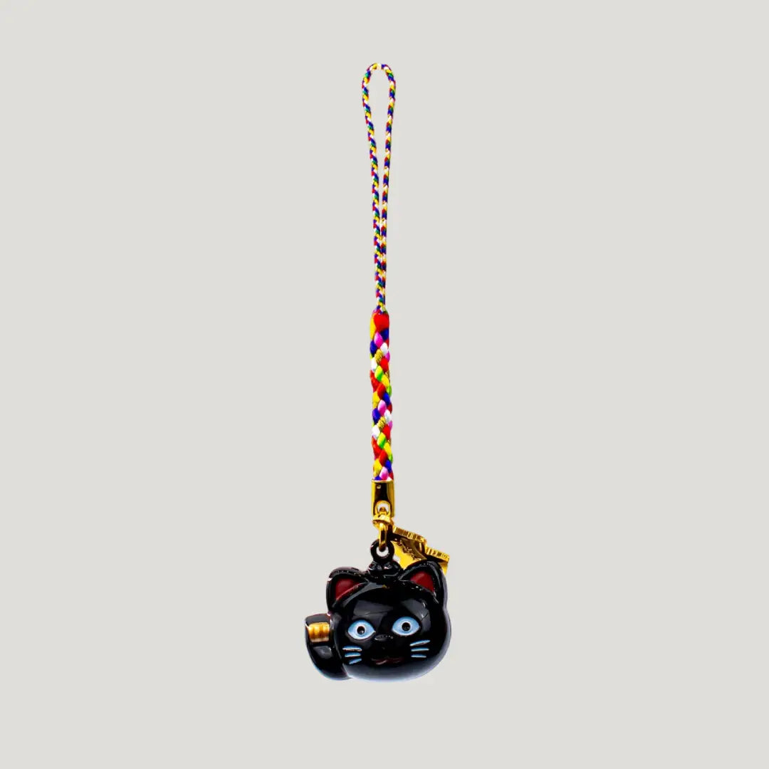 Fortune Beckoning Cat Omamori – back view of black maneki-neko bell charm with gold tag and multicolor strap from Shirasaki Shrine