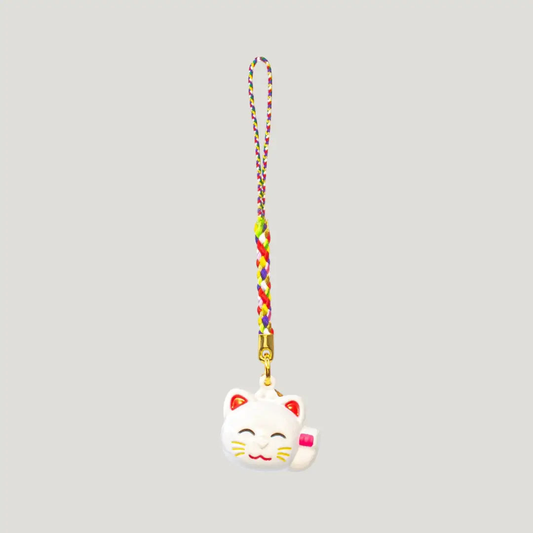 Fortune Beckoning Cat Omamori – white maneki-neko bell charm with multicolor strap from Shirasaki Shrine, symbolizing luck, wealth, and relationships