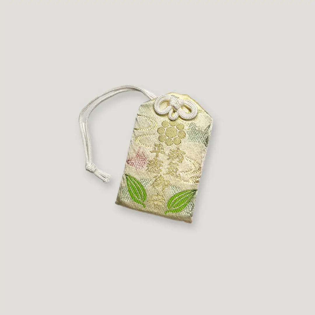 Front of healing omamori (病気平癒守) from Izusan Shrine – embroidered ivory charm for recovery, health, and well-being on black background
