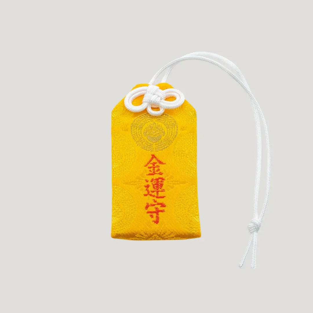 Front view of a traditional Japanese omamori for money luck from Saijo Inari temple, showing a vibrant yellow fabric with bold gold embroidered kanji characters.