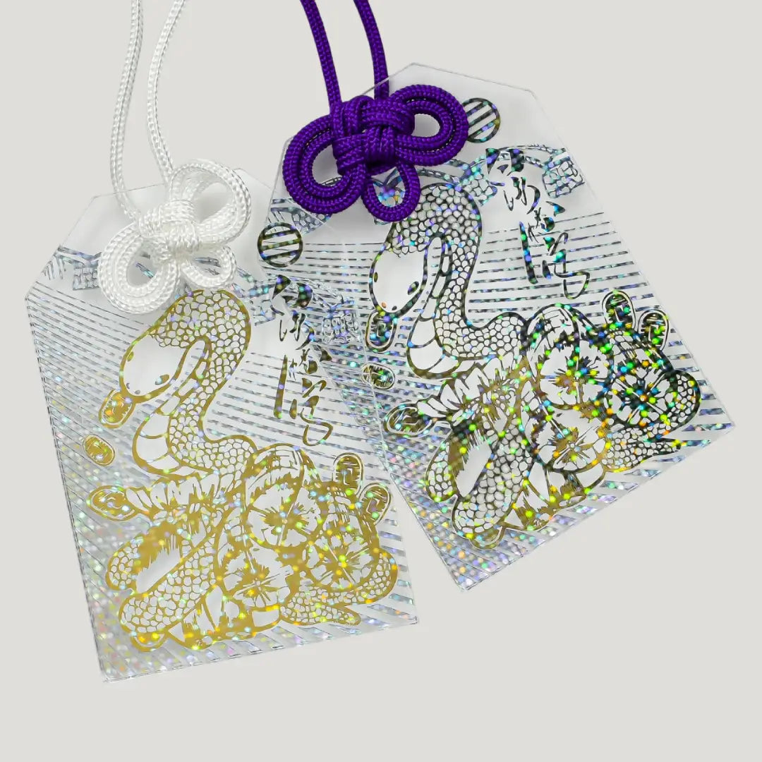 Shimmering White Snake Omamori with transparent design, gold foil white snake, and decorative knot cord from Shirasaki Shrine