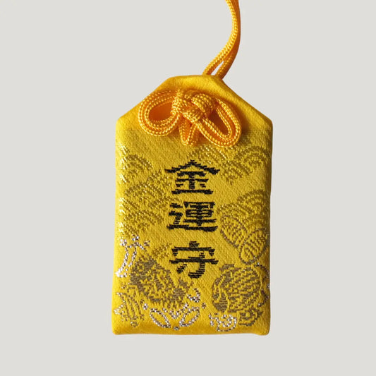 Wealth Omamori from Koenji Hikawa Shrine in yellow with gold embroidery and treasure motifs, symbolizing luck, prosperity, and financial blessings