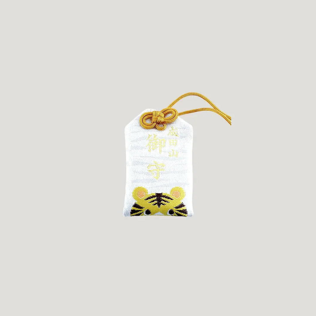 Tiger Zodiac Omamori from Osaka Naritasan Fudoson featuring a yellow tiger face with golden cord