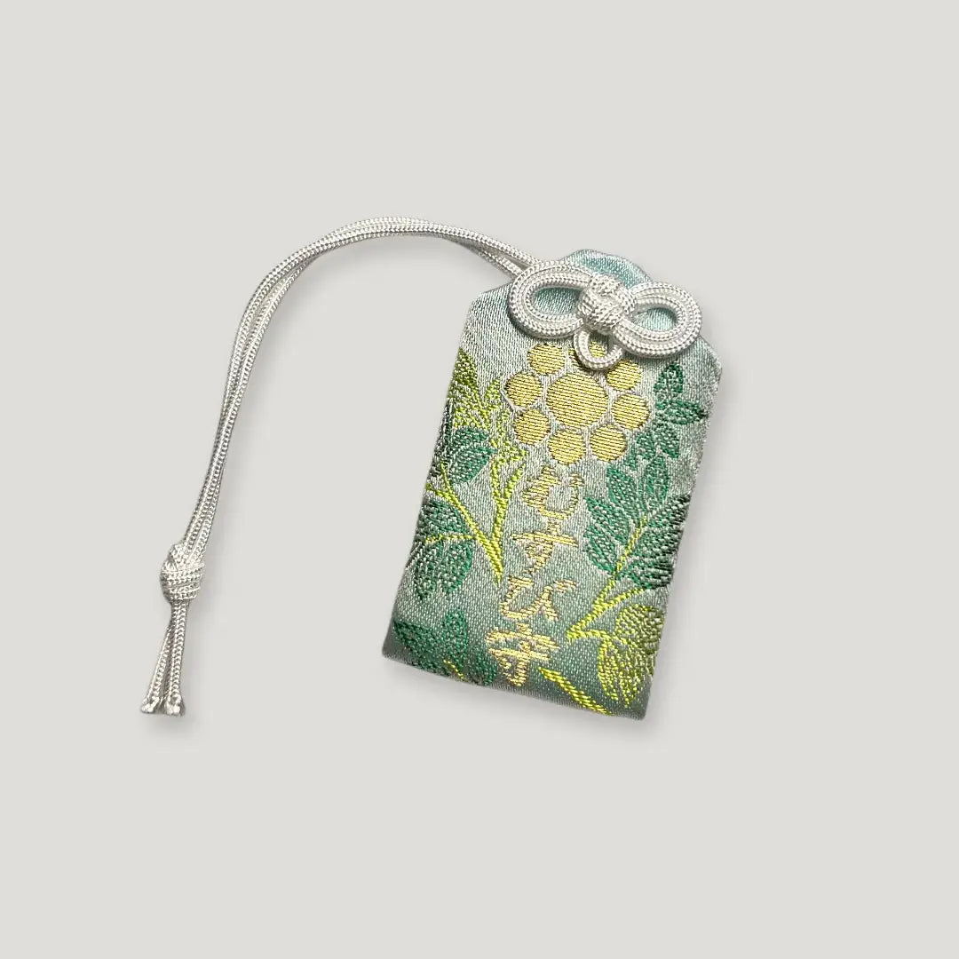 Front of connection and harmony omamori (むすび守) from Izusan Shrine – green Japanese charm with golden floral embroidery for unity and emotional balance