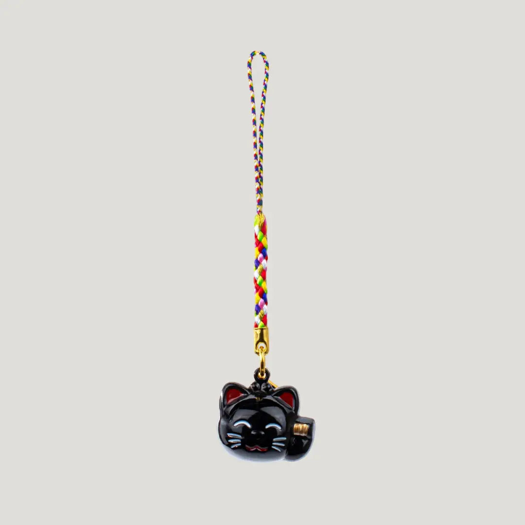 Fortune Beckoning Cat Omamori – black maneki-neko bell charm with multicolor strap from Shirasaki Shrine, symbolizing luck, wealth, and protection