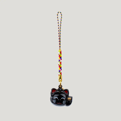 Fortune Beckoning Cat Omamori – black maneki-neko bell charm with multicolor strap from Shirasaki Shrine, symbolizing luck, wealth, and protection