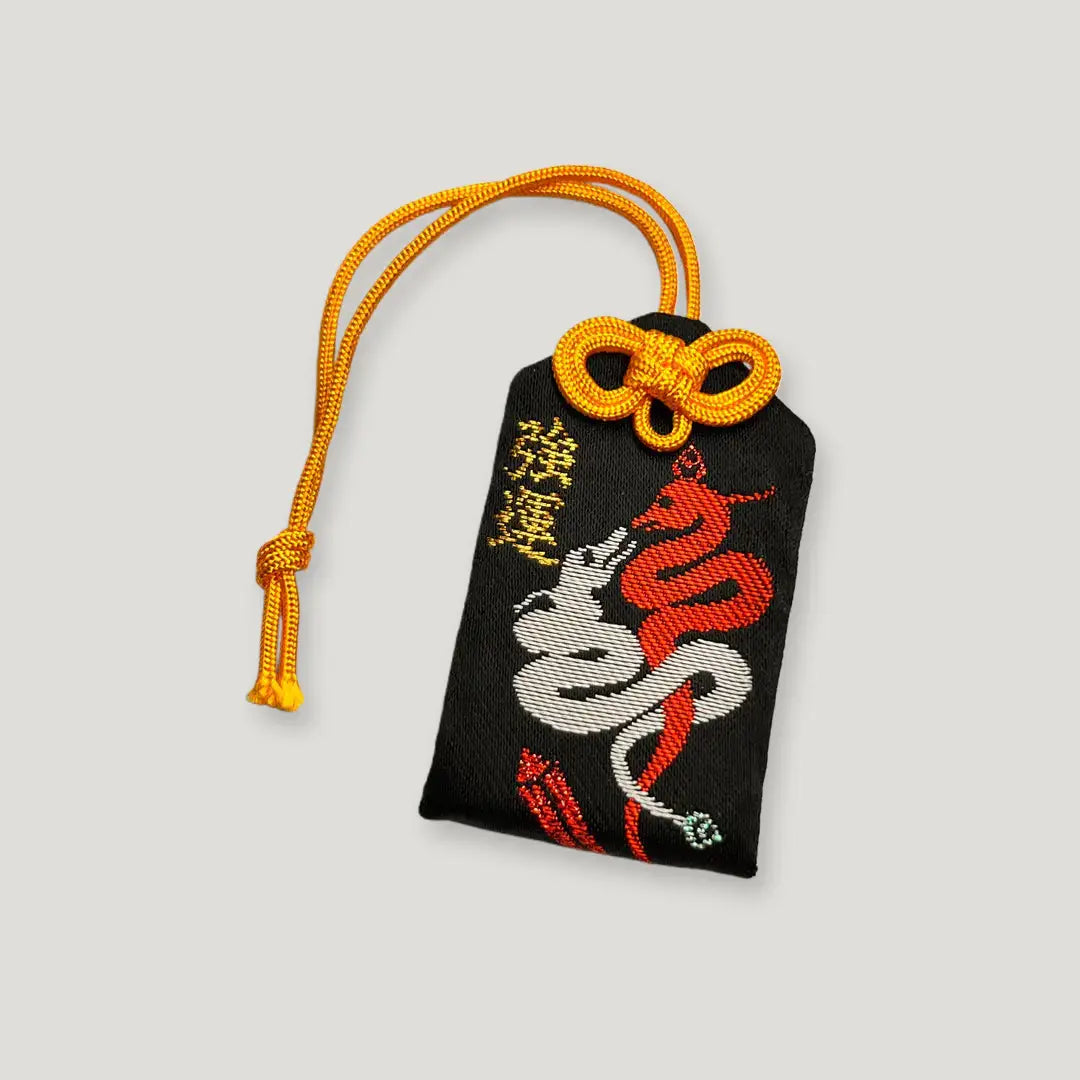Good luck omamori (強運守) from Izusan Shrine – black fabric charm with embroidered red and white snake for strong fortune and protection