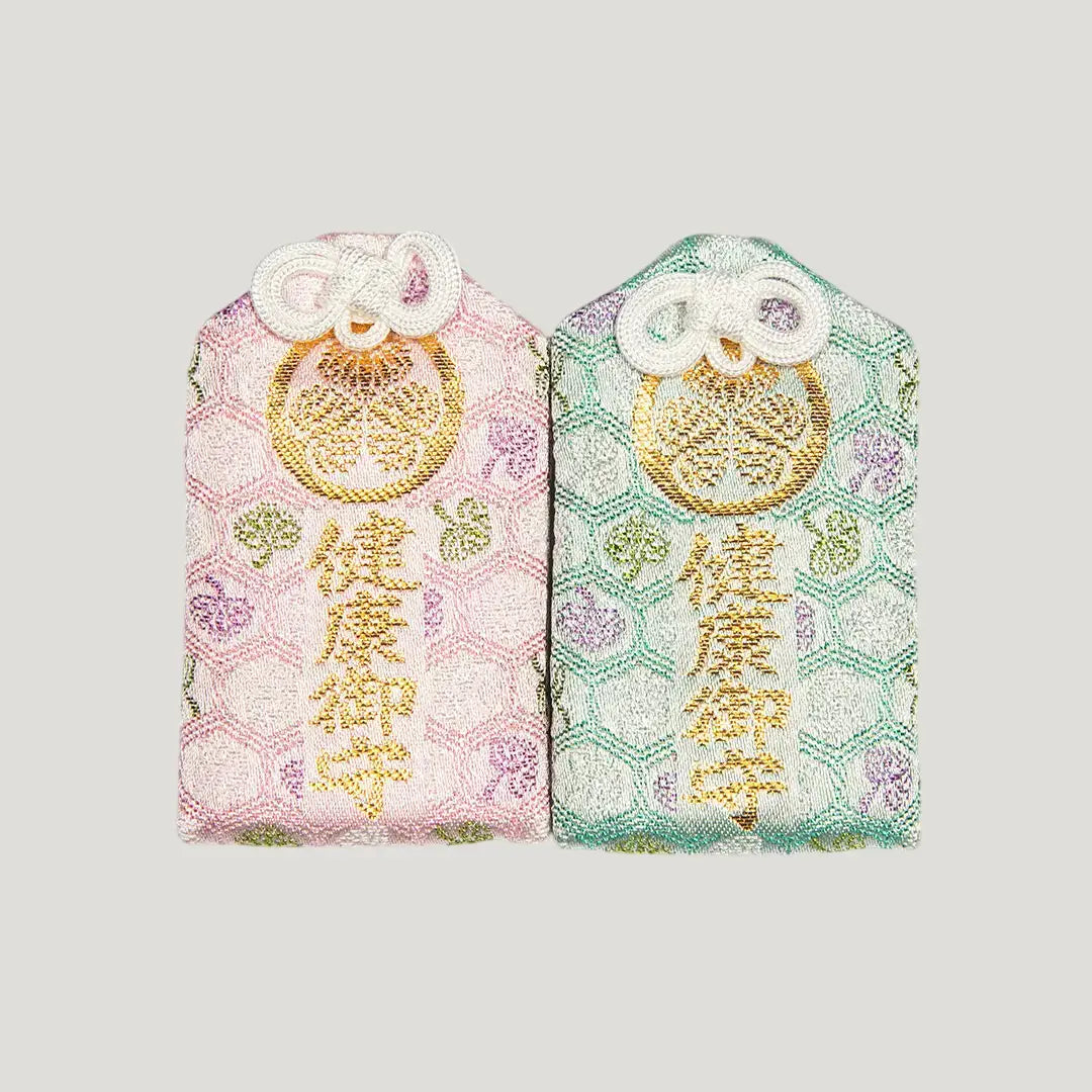 Front of 健康御守 (Health Protection Omamori) from Zojoji Temple – two color variants shown: pink and mint green with gold embroidery. Sold individually.