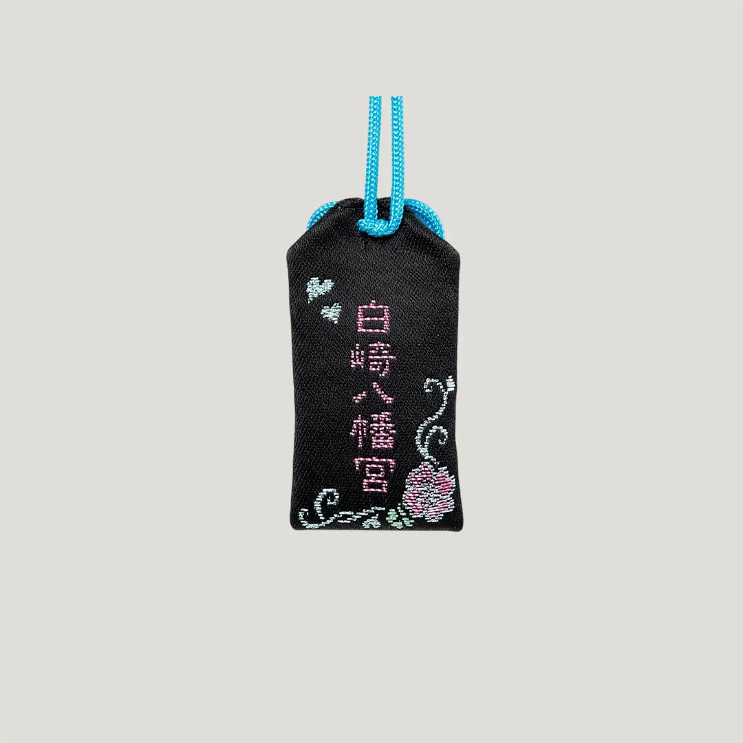 Back side of Love & Happiness Omamori from Shirasaki Hachimangu Shrine – black with pink embroidery, floral and heart motifs, and blue cord