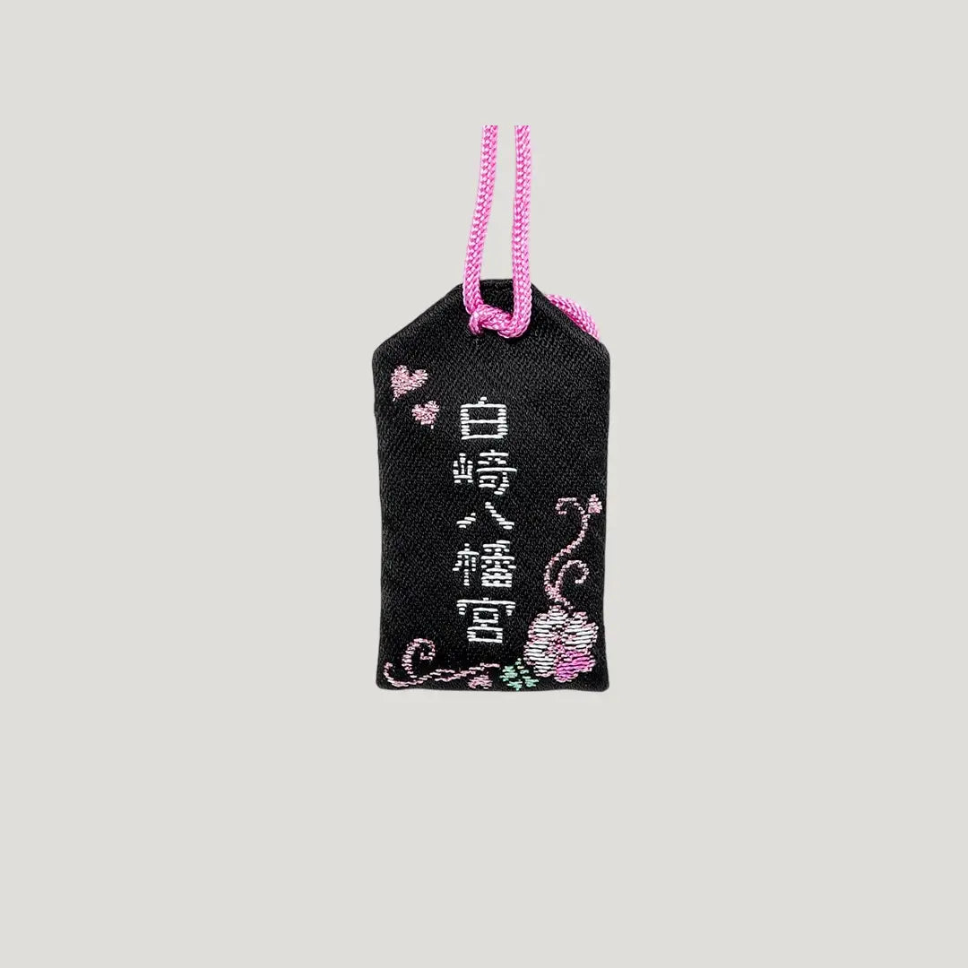 Back side of Love & Happiness Omamori from Shirasaki Hachimangu Shrine – black with white and pink embroidery, floral and heart design