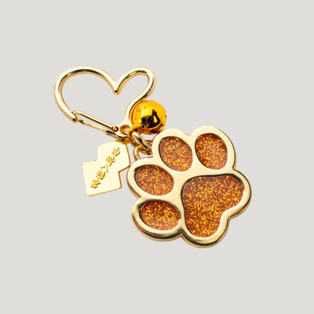 Pet Joy Omamori (ペットよろこび守) – glittery orange paw-shaped Japanese charm with gold heart clip from Shirasaki Shrine, for pet happiness and safety