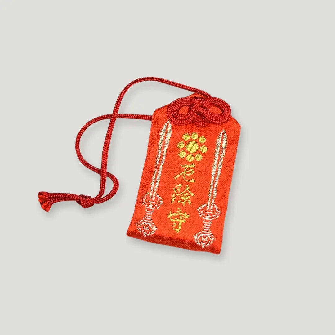 Front of protection from misfortune omamori (厄除守) from Izusan Shrine – red Japanese charm with twin sword embroidery for warding off bad luck
