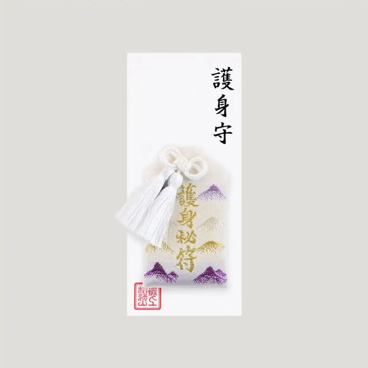 White Protection Omamori from Saijo Inari Shrine with gold and purple mountain design.