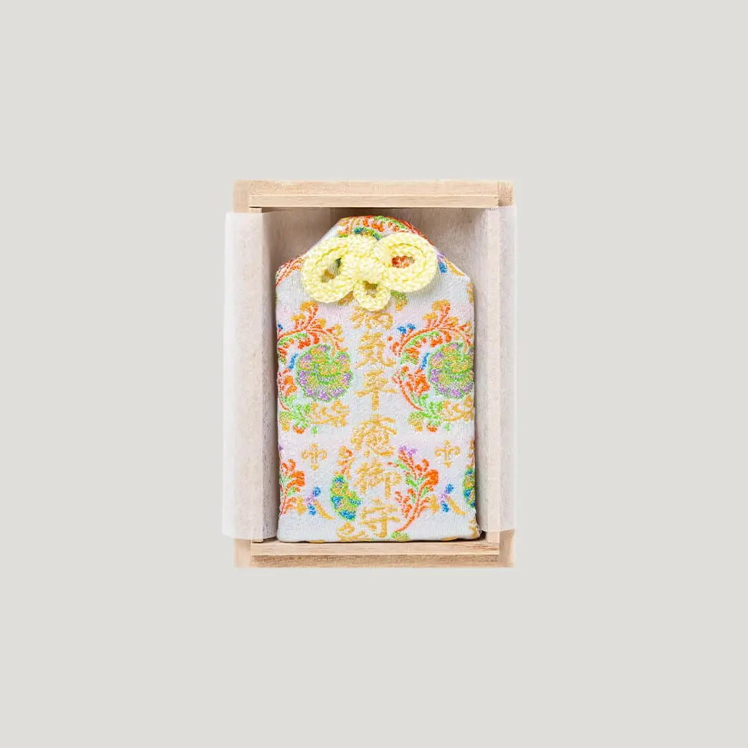 Back of Recovery and Healing Omamori with white and multicolor embroidery in wooden box from Shirasaki Shrine