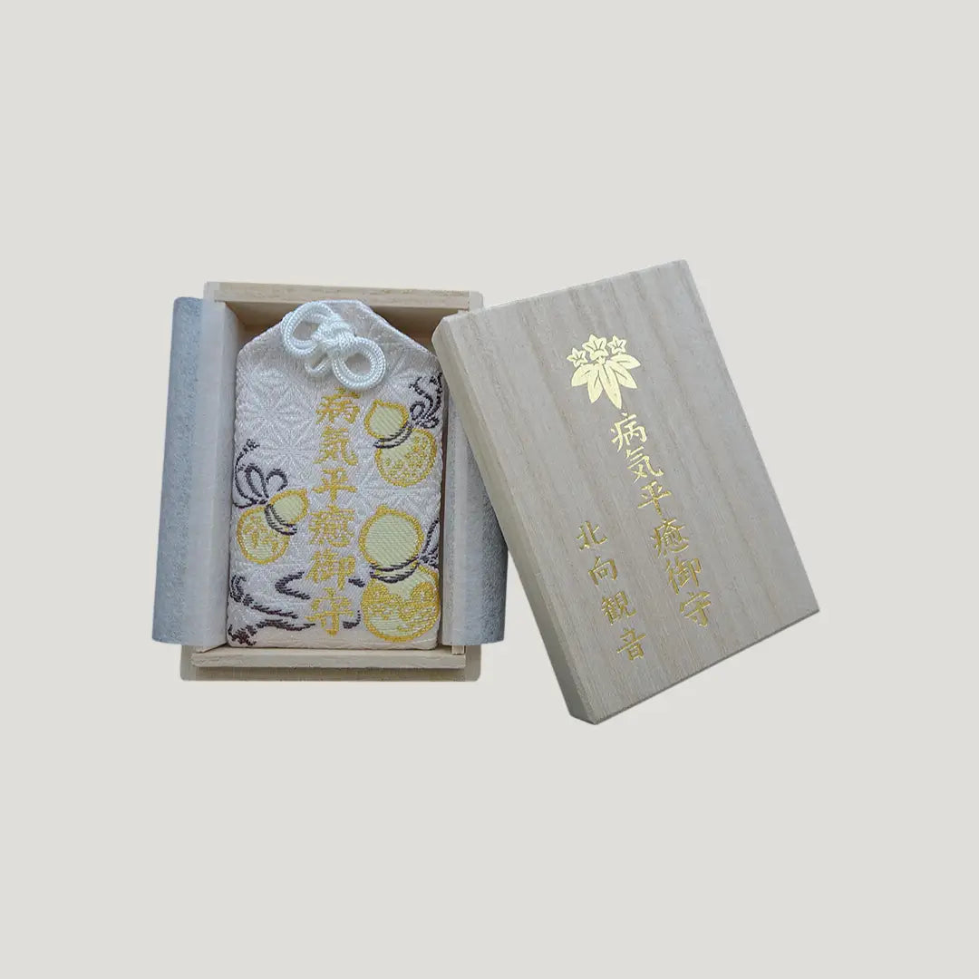 Recovery & Healing Omamori from Kitamuki Kannon Temple shown in an open wooden box with the lid placed beside it