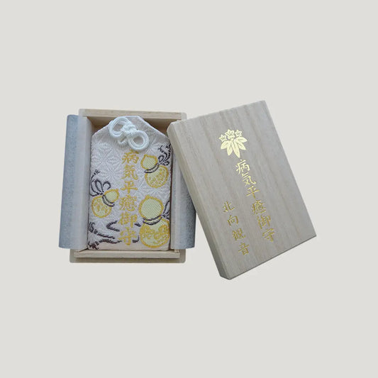Recovery & Healing Omamori from Kitamuki Kannon Temple shown in an open wooden box with the lid placed beside it