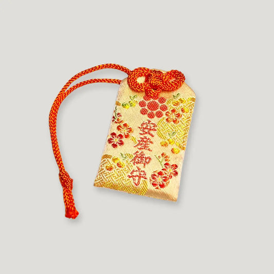 Front of safe childbirth omamori (安産守) from Izusan Shrine, gold and red variant – authentic Japanese omamori for pregnancy and smooth delivery blessings