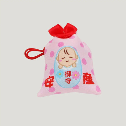 Close-up of Safe Childbirth Omamori (安産お守り) – baby design on pink charm with red bow and polka dots, symbolizing pregnancy protection from Shirasaki Shrine