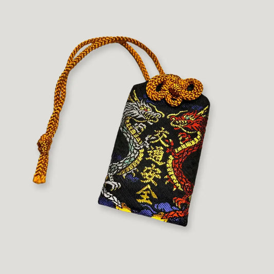 Safe travel omamori (交通安全守) from Izusan Shrine – embroidered black charm with red and silver dragons for protection in transit