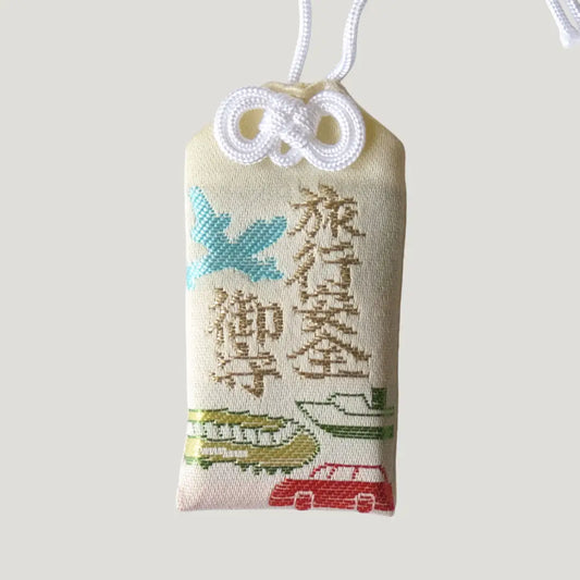 Safe Travel Omamori from Koenji Hikawa Shrine with embroidered airplane, train, car, and ship, symbolizing protection across all types of journeys