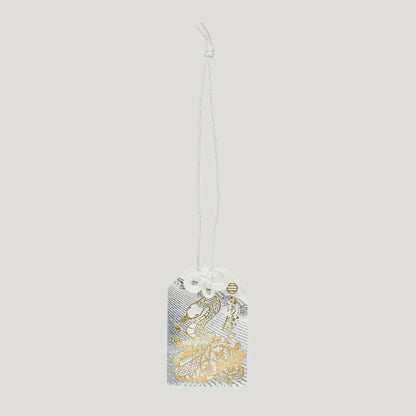 Shimmering White Snake Omamori with gold foil design and white decorative cord from Shirasaki Shrine