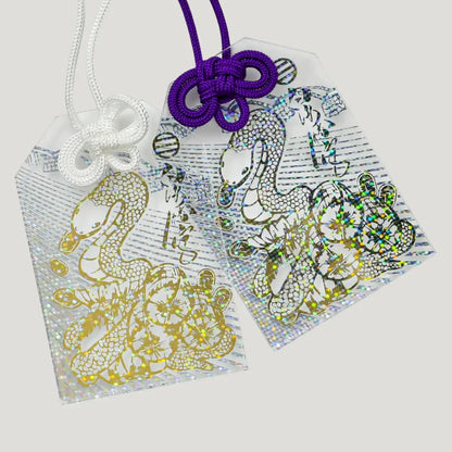 Shimmering White Snake Omamori with transparent design, gold foil white snake, and decorative knot cord from Shirasaki Shrine