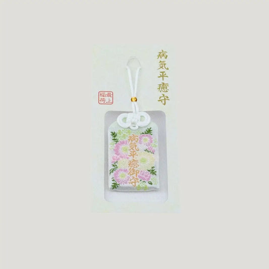 A traditional Japanese omamori for sickness recovery from Saijo Inari temple, showing a white fabric with delicate floral embroidery on its original card.