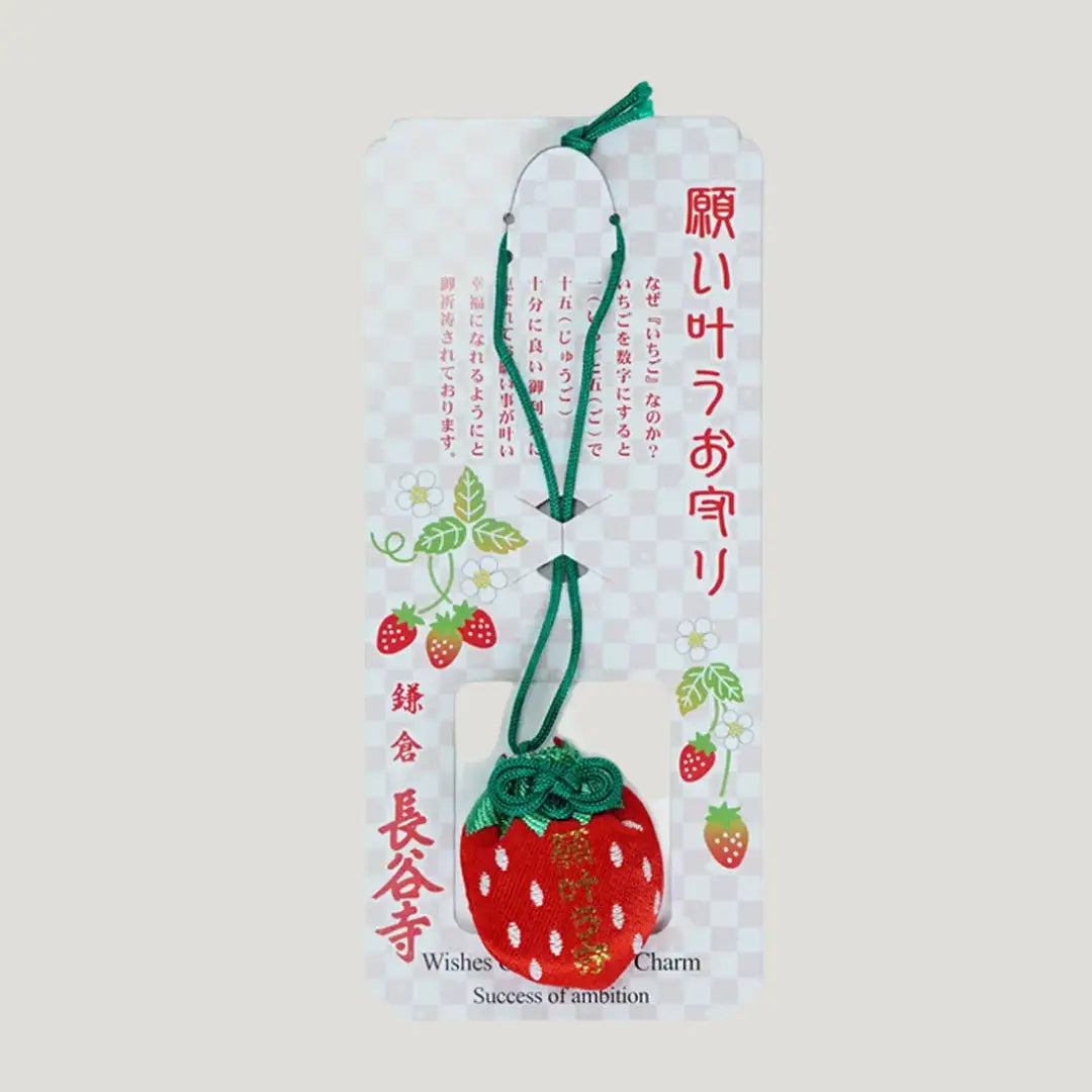 Packaged strawberry-shaped 願い叶う守 (Wish-Fulfillment Omamori) from Hasedera Temple – red charm with green cord on illustrated backing card featuring strawberries, flowers, and Japanese explanation text
