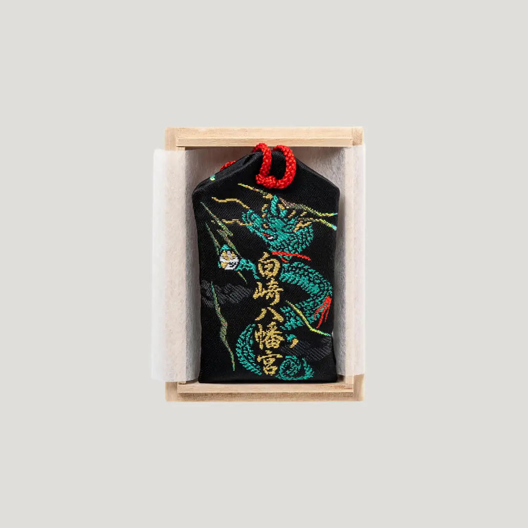 Back of Sure Victory Omamori from Shirasaki Shrine – black fabric with embroidered green dragon and shrine name, includes wooden box