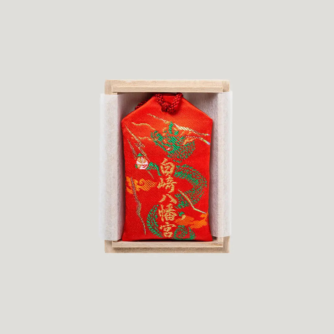 Back side of Sure Victory Omamori from Shirasaki Shrine – red fabric with dragon and tiger embroidery, includes wooden gift box