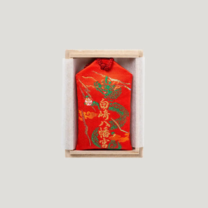 Back side of Sure Victory Omamori from Shirasaki Shrine – red fabric with dragon and tiger embroidery, includes wooden gift box