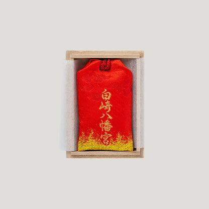 Back view of the Victory Fortune Omamori in a wooden presentation box from Shirasaki Hachimangu in Japan