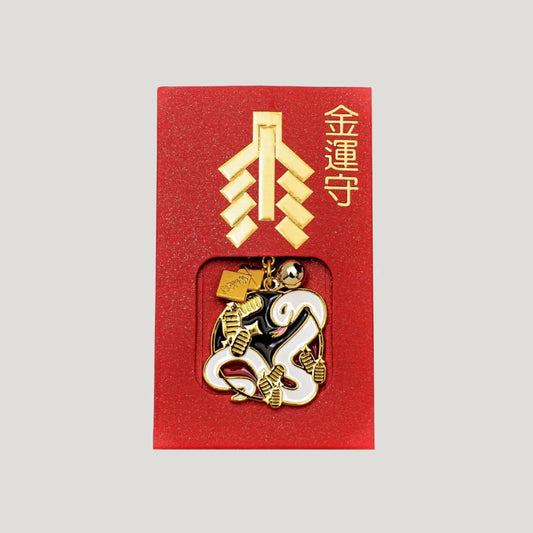 White Snake Wealth Omamori from Shirasaki Hachimangu Shrine, gold and white charm in red packaging for prosperity and good fortune.